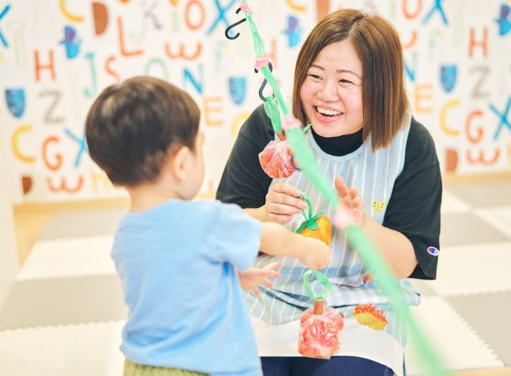 子どもと笑顔でふれあう保育士